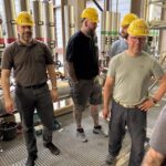 Kursteilnehmer mit KVA-Schutzhelmen im Kesselhaus der KVA Buchs